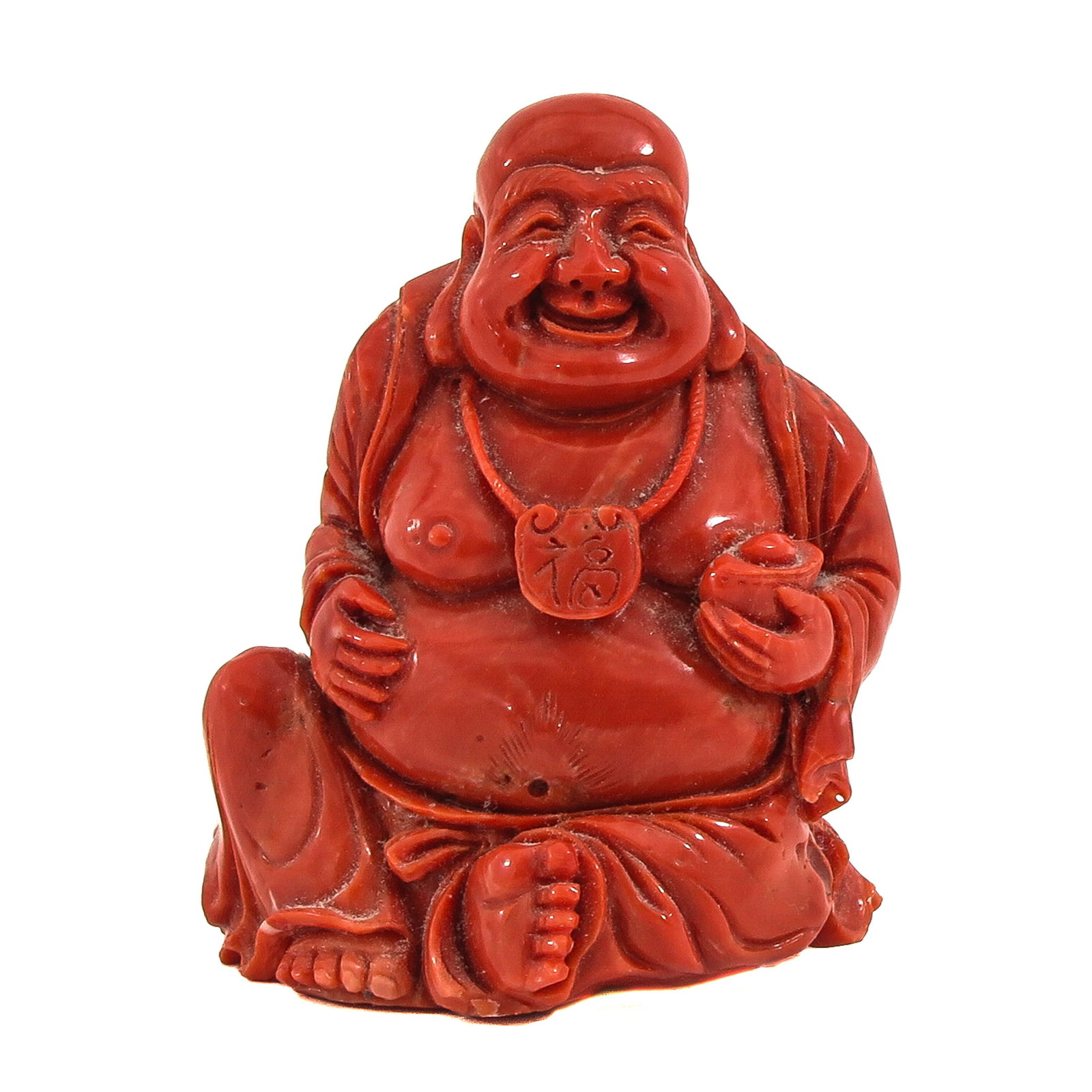 A Carved Red Coral Sculpture: Depicting a laughing Buddha holding a bowl, 8 cm tall,