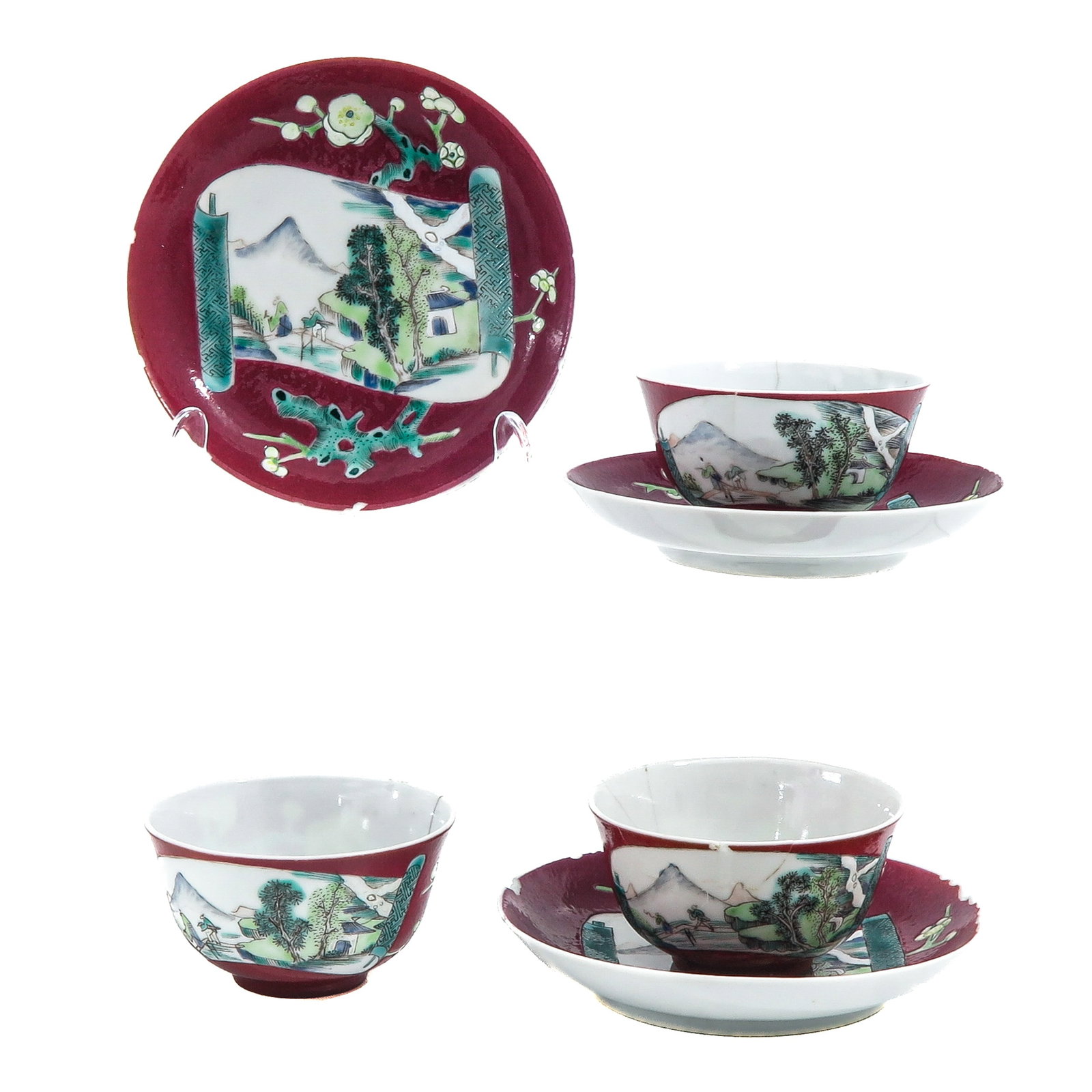 A Group Famille Rose Cups and Saucers: Ruby ground with scroll shaped panel with a landscape and a flowering prunus behind, 18th Century, saucers are 13 cm in diameter, in diverse conditions.