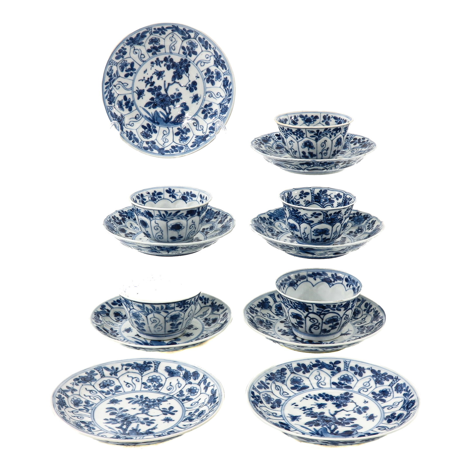 A Set of Blue and White Cups and Saucers: Richly decorated with floral scrolls, flowering plants in a garden scene with paneled design border, 18th Century, saucers are 11 cm in diameter, chip and hairline.