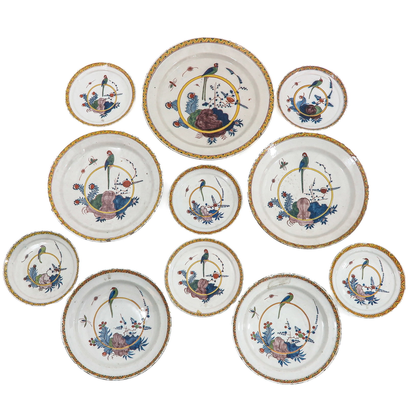 A Collection of Plates: consisting of 11 polychrome painted earthenware plates with parrot decoration, 18th century, largest diameter 40 cm., various condition