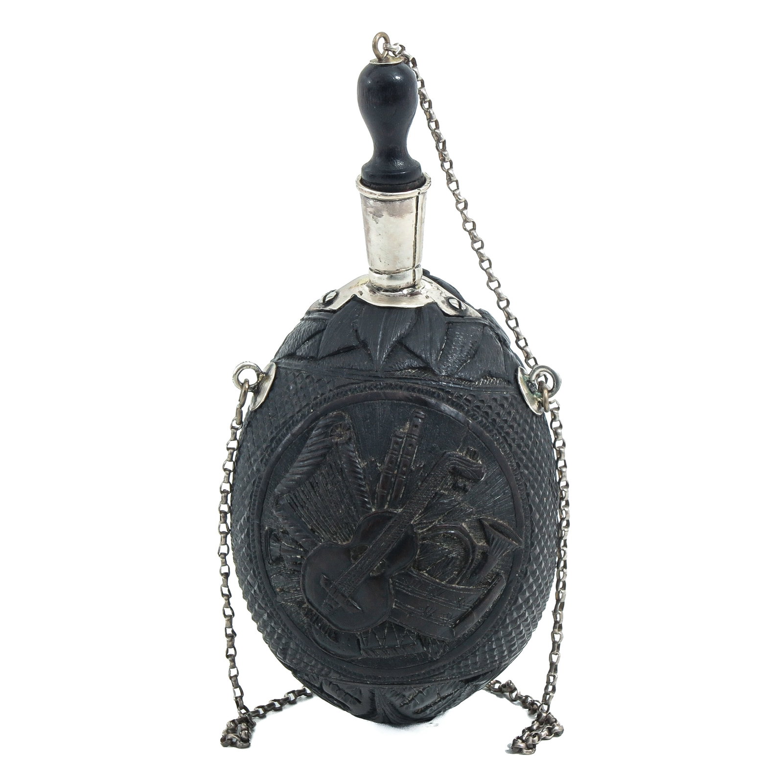 A Powder Horn: carved coconut, with silver mount, decorated in relief with musical instruments and fitted with chain, height 18 cm.