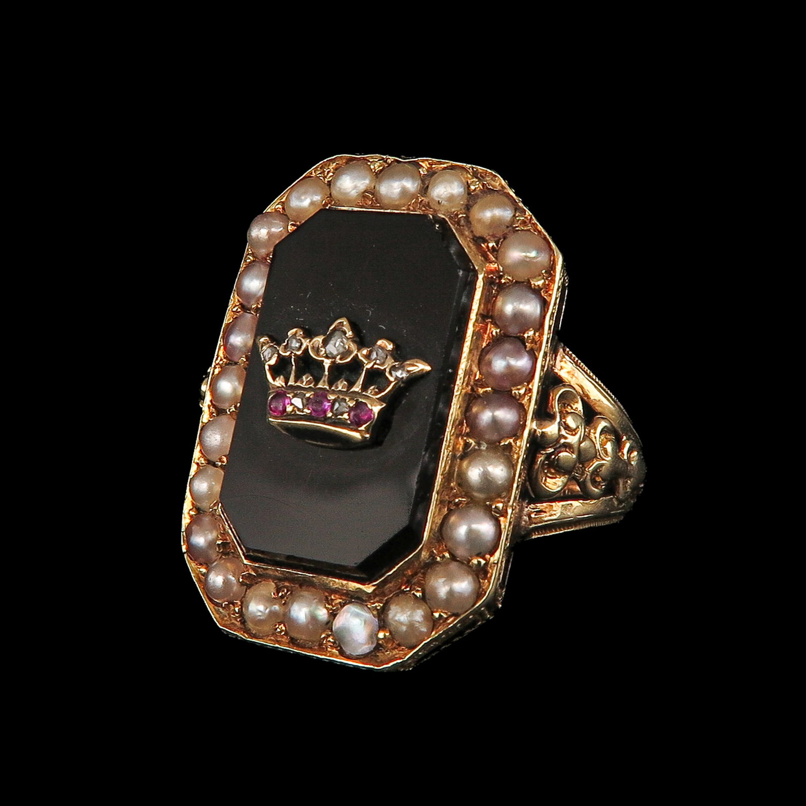 A Ladies' 19th Century Ring: 19th century, 18 Krt. gold, set with onyx, provided with a crown motif with diamonds, surrounded by a border of seed pearls, ring size 17
