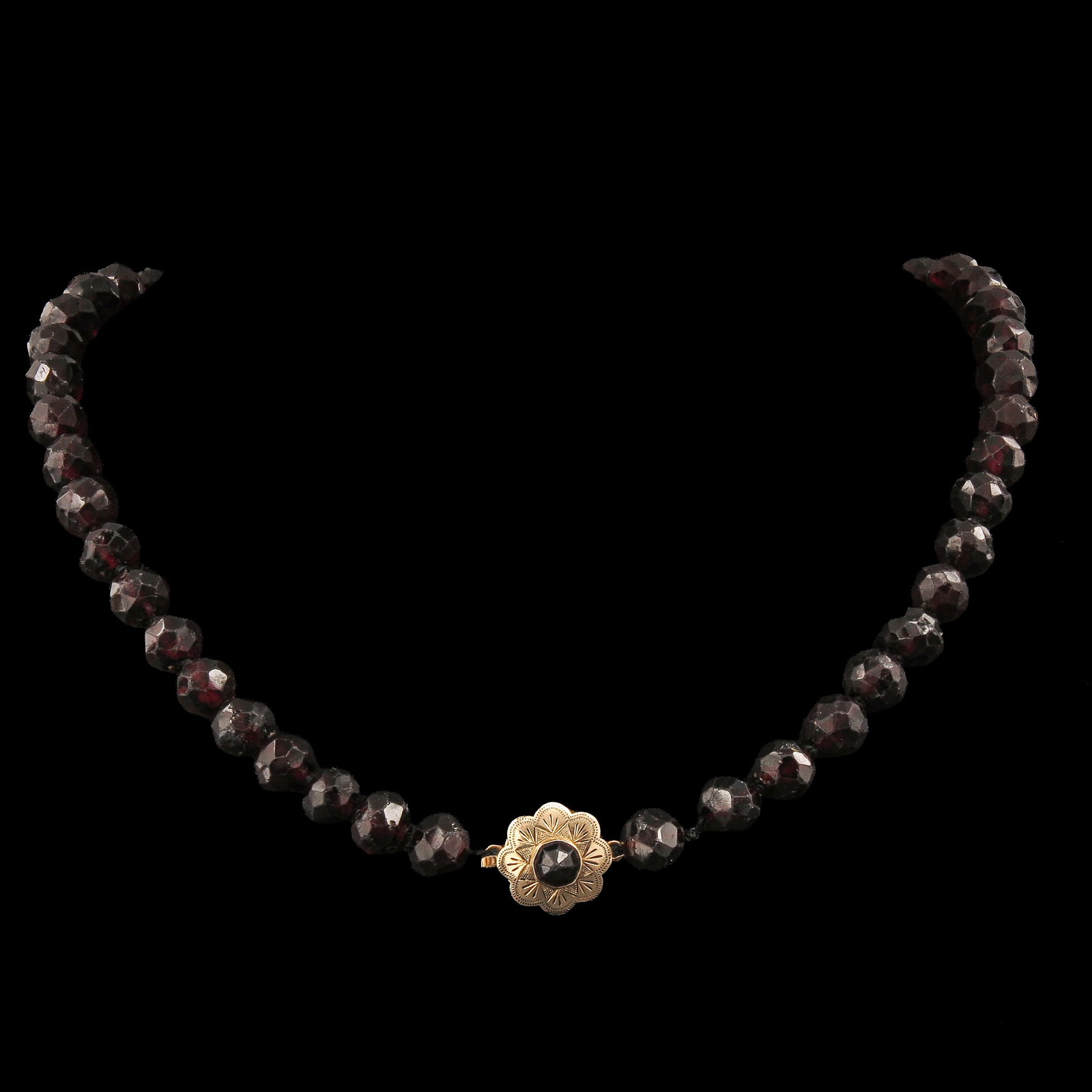 A Garnet Necklace: faceted garnets, length 42 cm., with gold clasp