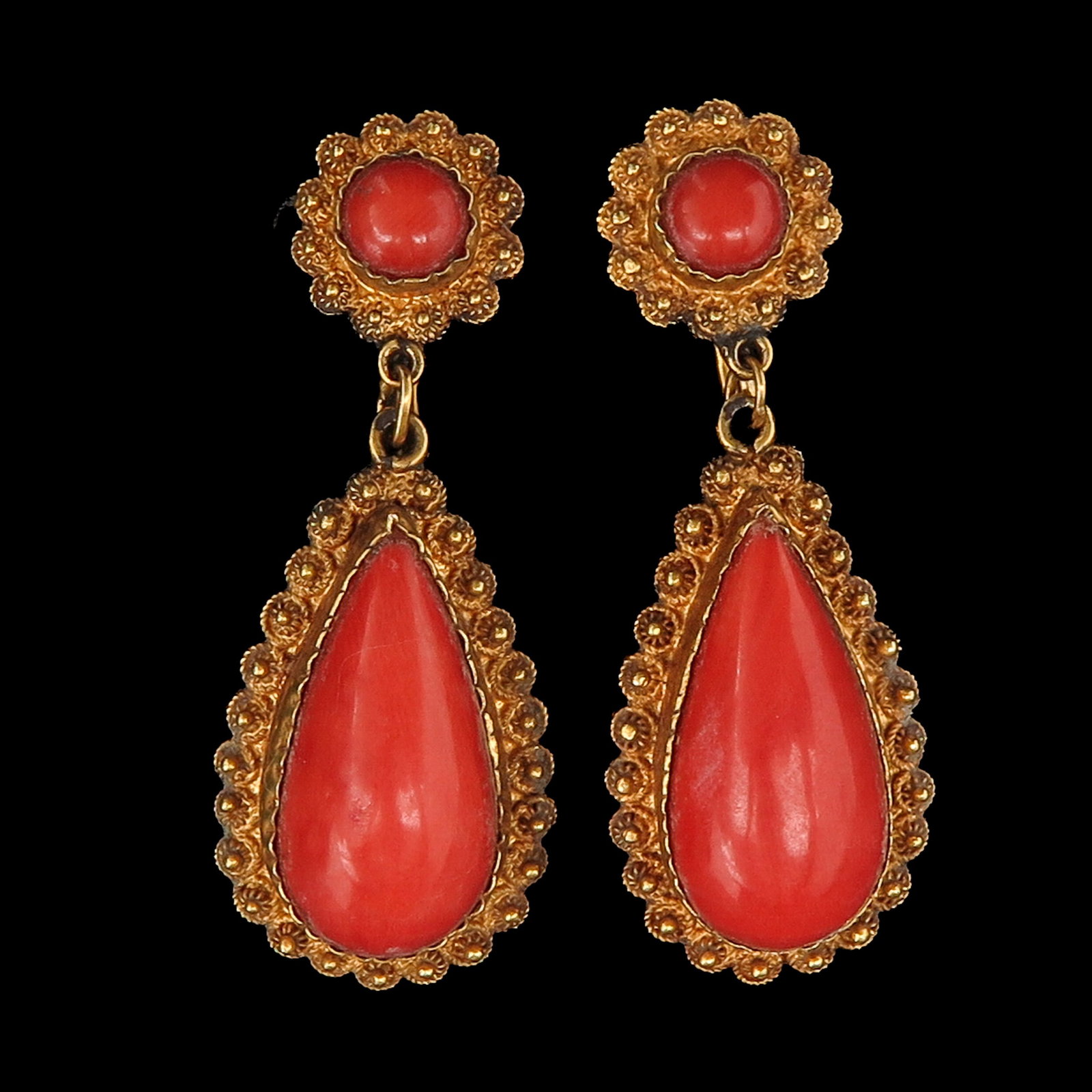 A Pair of 14KG Earrings: set with red coral in a finely worked setting, length 40 mm.
