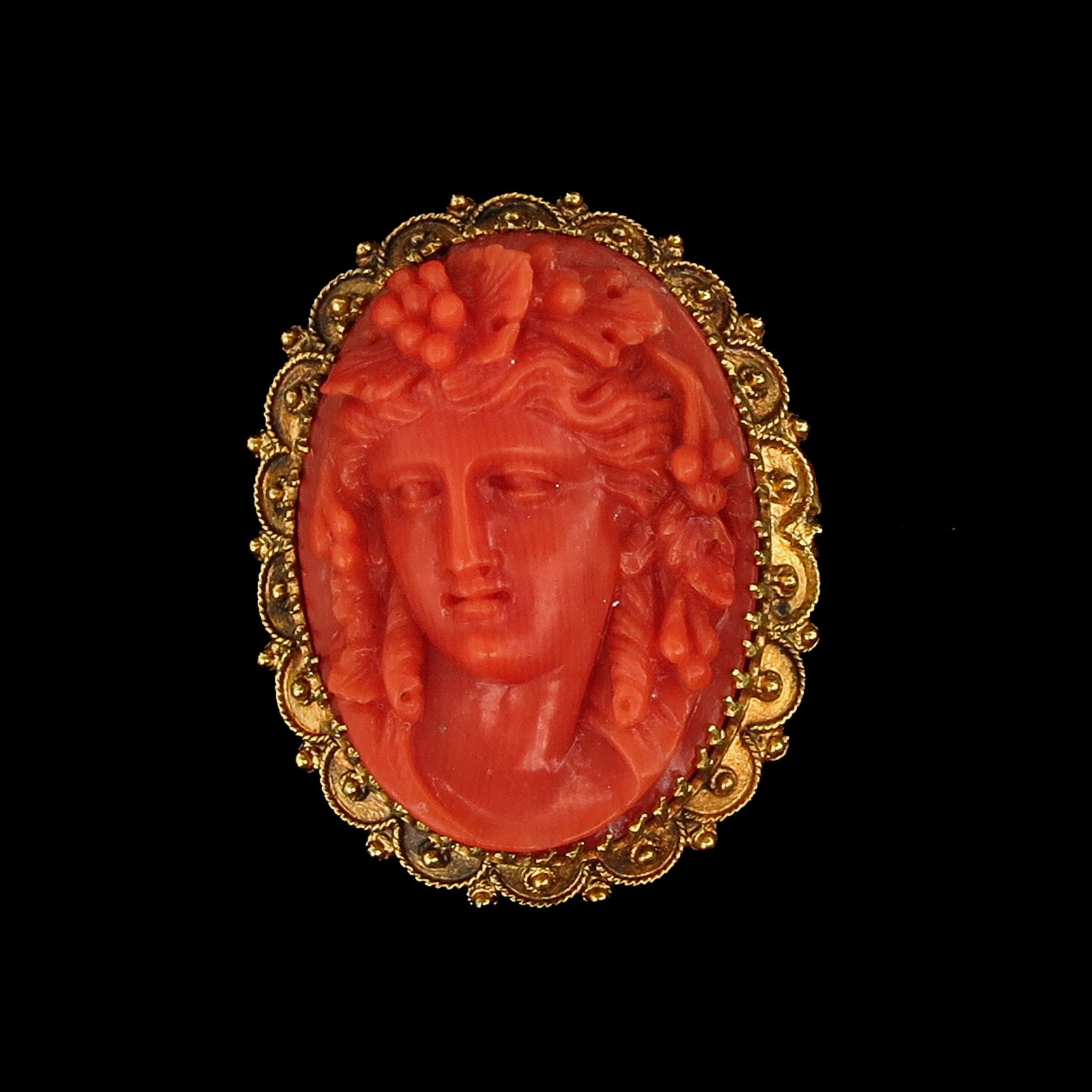 A 14KG Brooch: 14 Krt. gold, with cameo of red coral, length 27 mm.