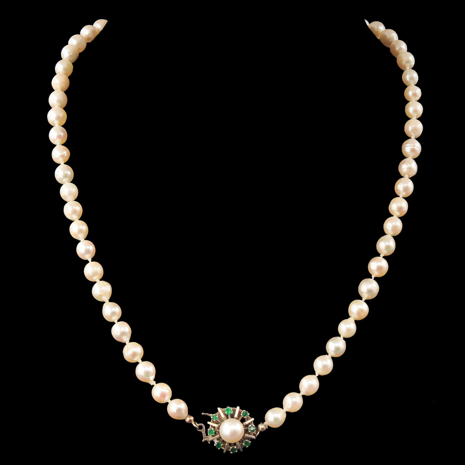 A Pearl Necklace: pearls, with 14 Krt. gold clasp set with emeralds, length 46 cm.