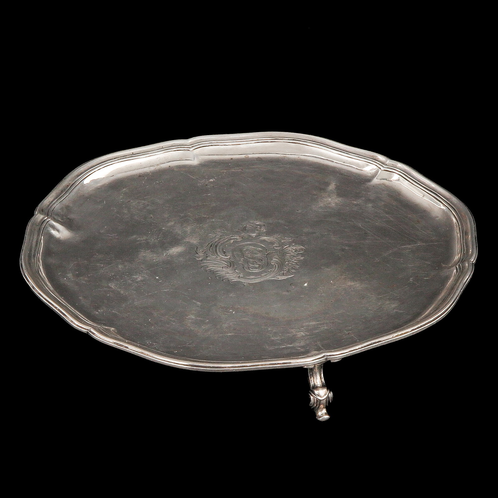 A Silver Cabaret: silver, 18th century, engraved with a central coat-of-arms cartouche, diameter 23 cm.