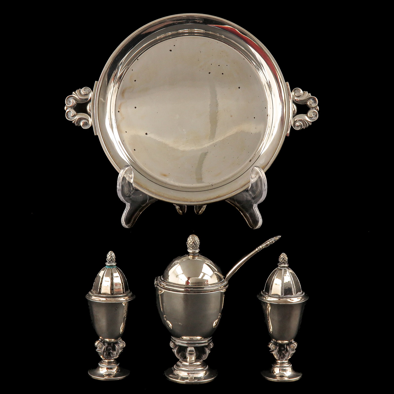 A Georg Jensen Cruet Set: consisting of a tray with handles, a mustard pot with spoon and a pepper and salt shaker, sterling silver, Georg Jensen, model Acorn, designed by Johan Rohde, tray 18 cm. wide including handles