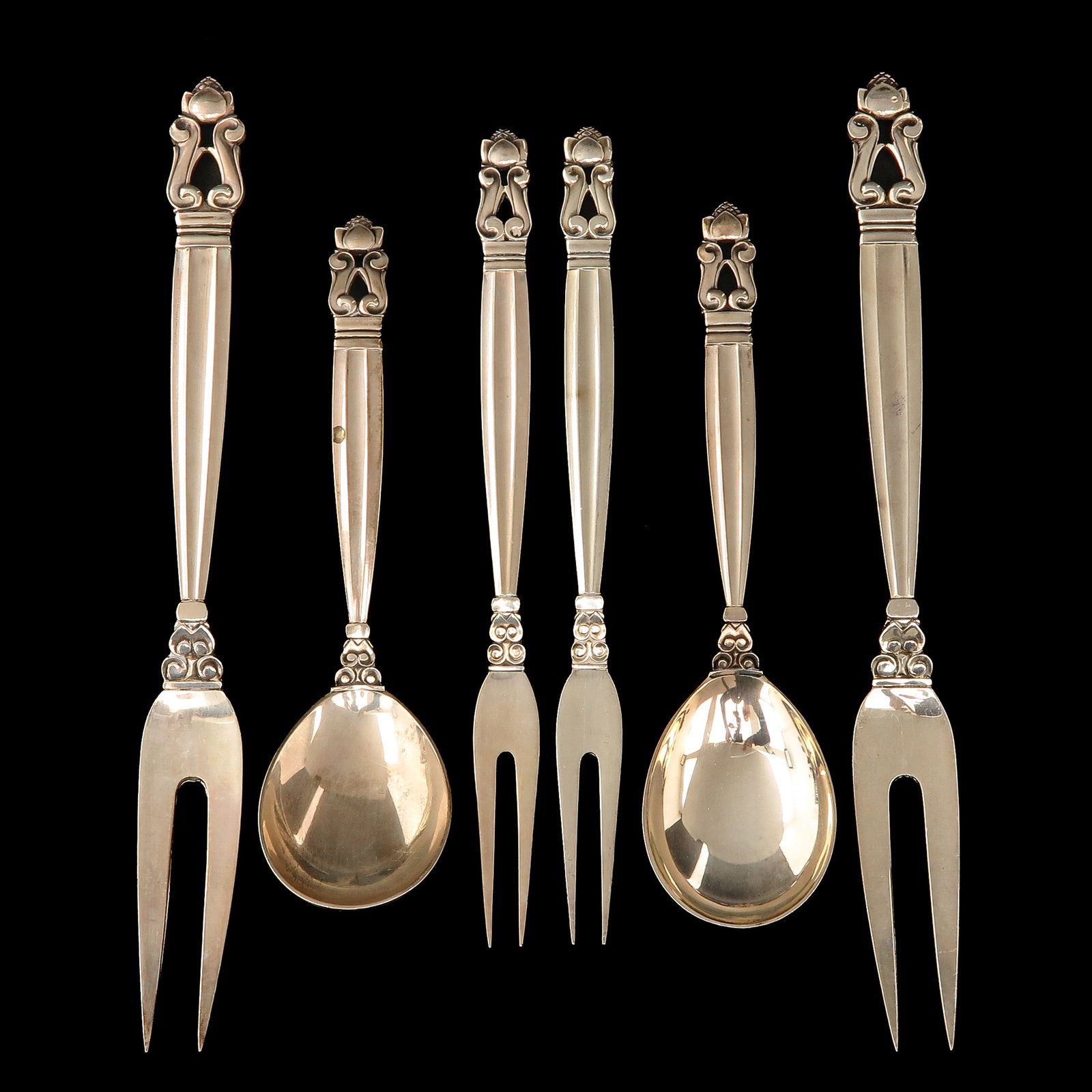 A Set of Georg Jensen Cutlery: consisting of 2 jam spoons, 2 meat forks and 2 cold meat forks, sterling silver, Georg Jensen, model Acorn, designed by Johan Rohde, longest 20 cm.