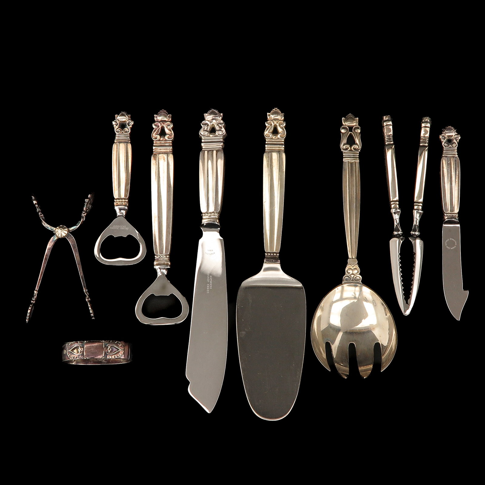 A Set of Georg Jensen Cutlery: including sugar tongs, two bottle openers, a cake server, sterling silver, Georg Jensen, model Acorn, designed by Johan Rohde, longest 23 cm.