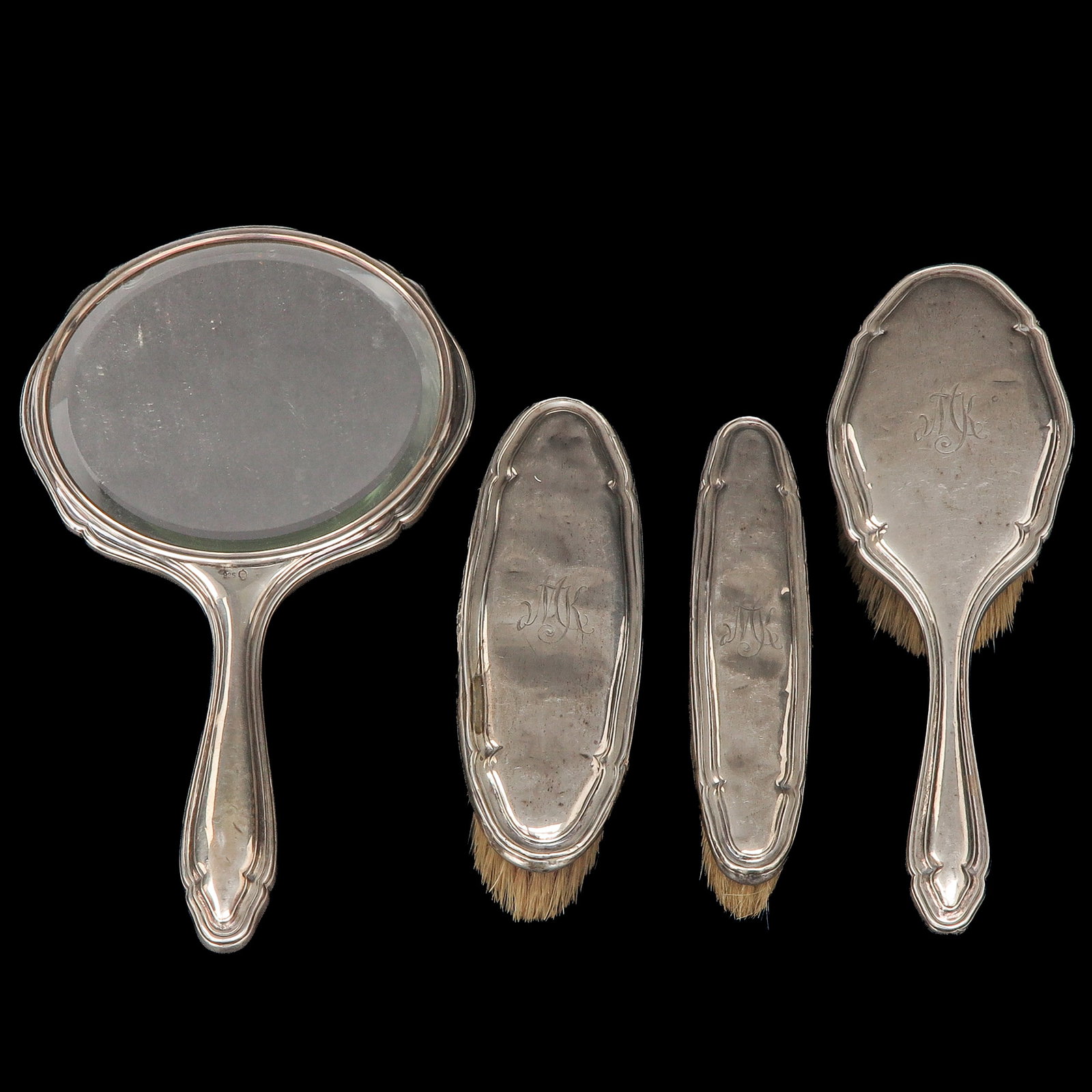 A Silver Vanity Set: silver, consisting of a hand mirror and 3 brushes, longest 25 cm.