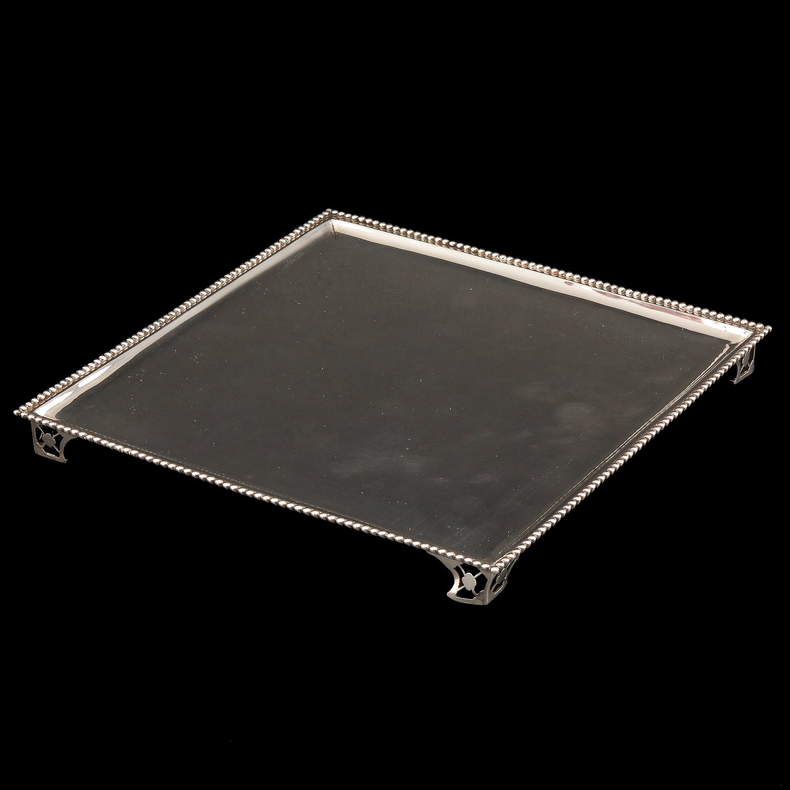A Silver Cabaret: silver, Amsterdam, 18th century, rectangular executed with pearl border and resting on four pierced feet, 23 x 23 cm.