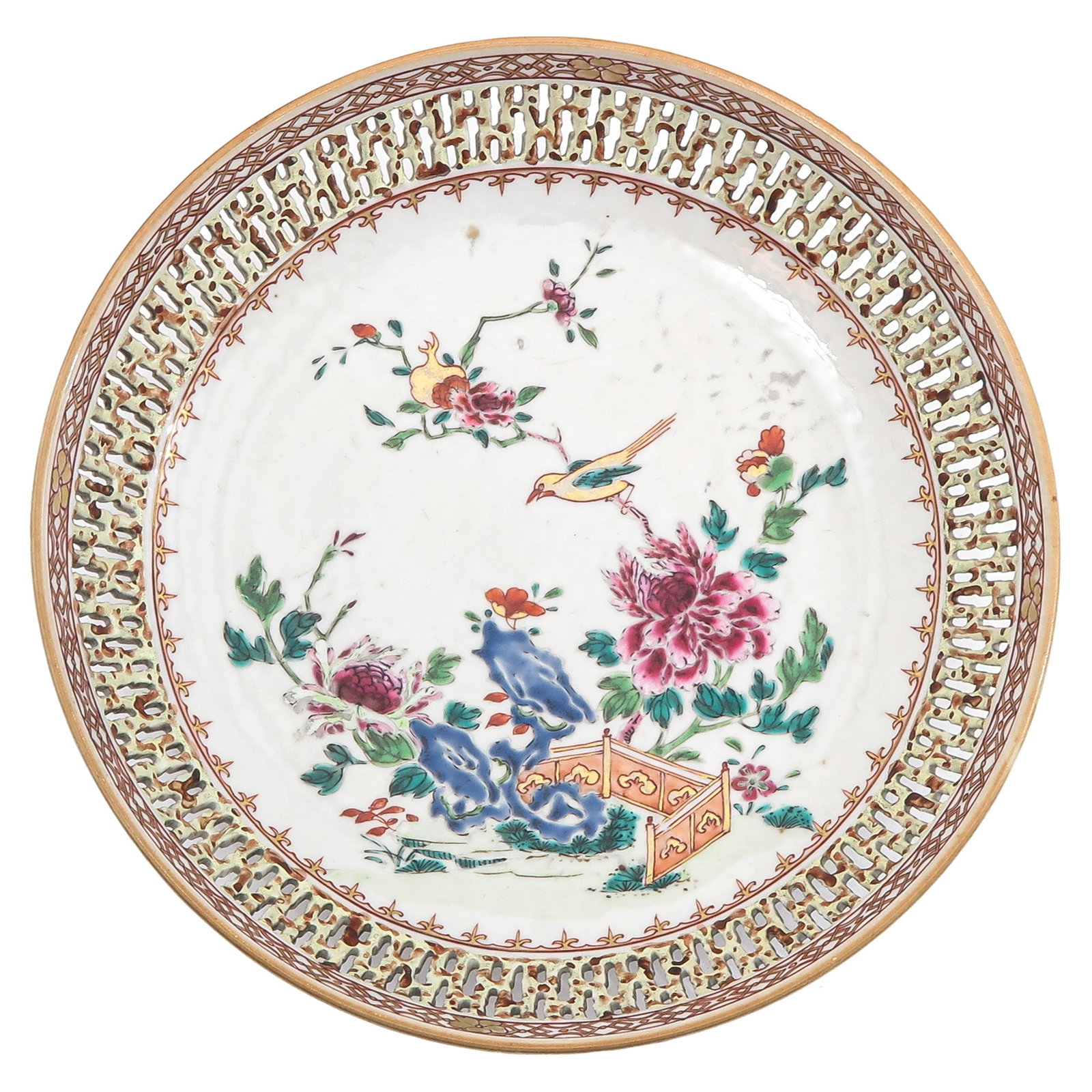 A Famille Rose Plate: Pierced border, decorated with flowering peonies, rockwork and a bird in a garden setting, 26 cm. in diameter.
