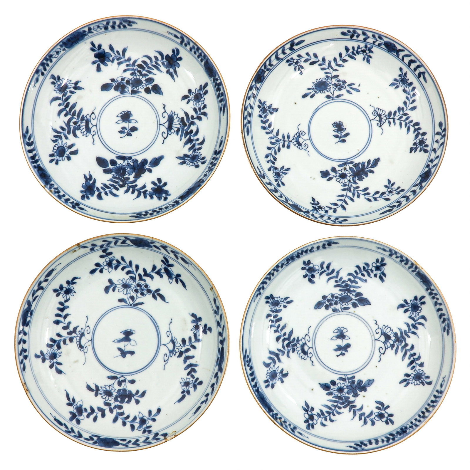 A Series of 4 Blue and White Plates: Flowering motifs, 18th Century, 22 cm. in diameter, chip and hairline.