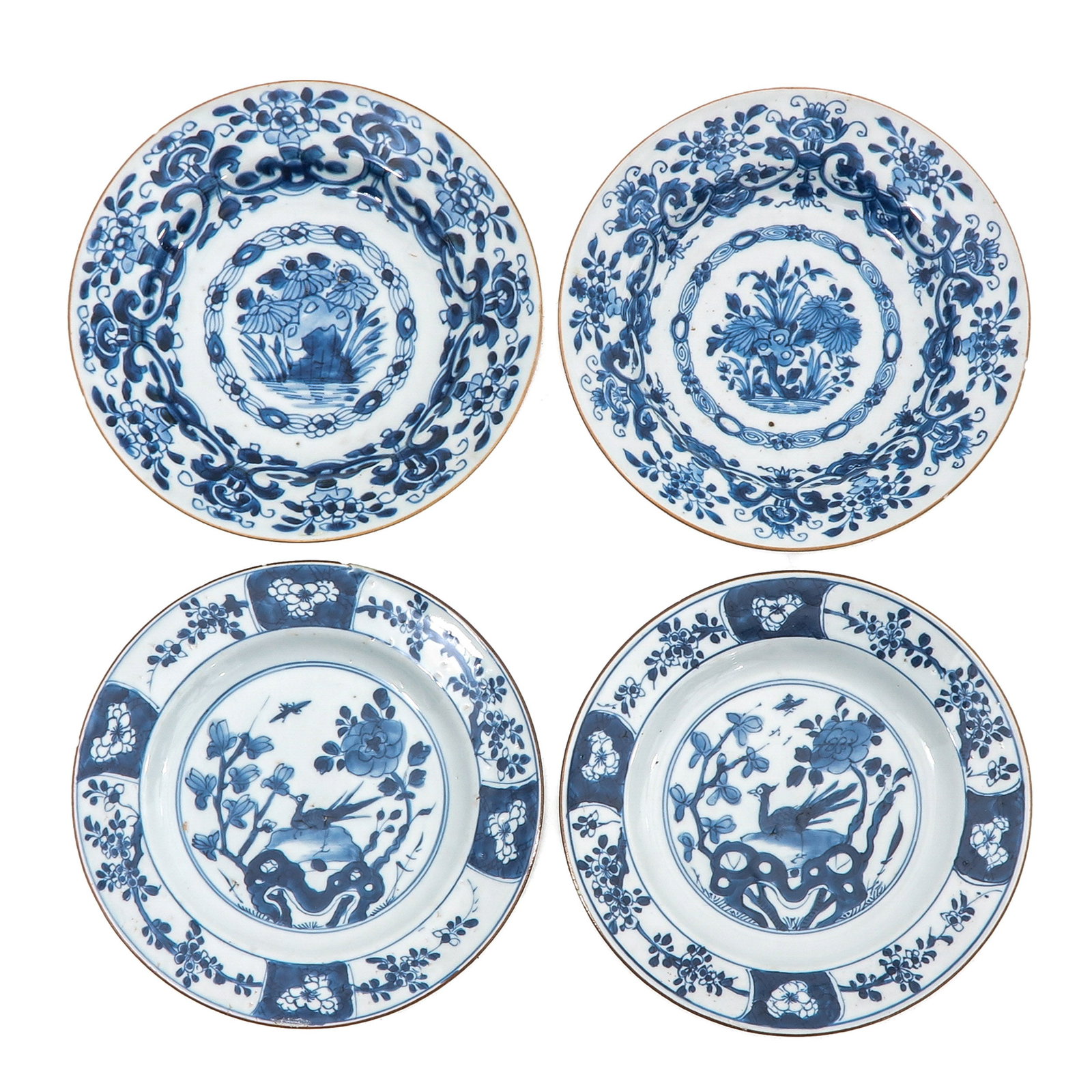 A Group of 4 Blue and White Plates: Including 2 examples decorated with flowering plants and 2 with birds in a garden landscape, 23 cm. in diameter, chip.