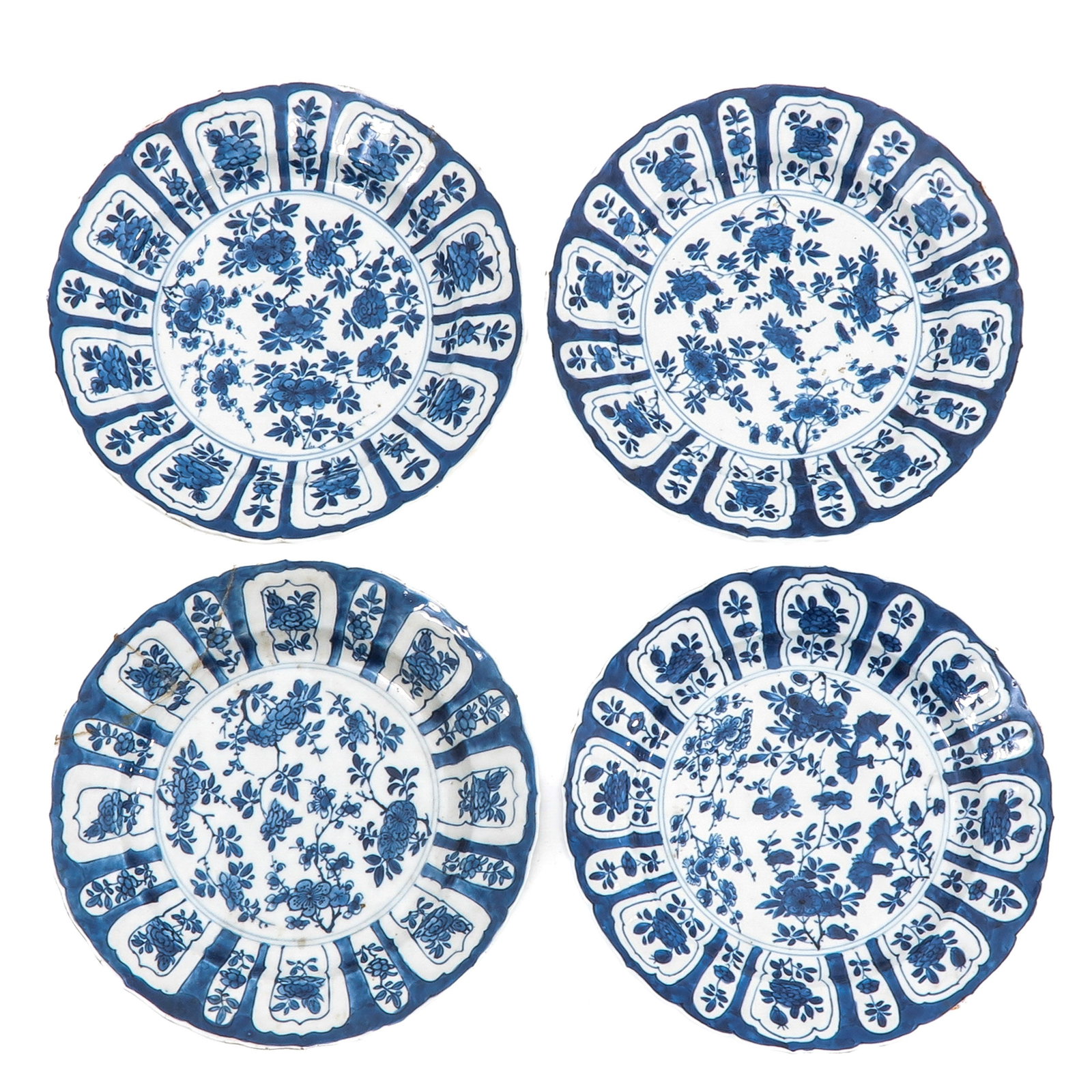 A Series of 4 Blue and White Lobed Plates: Decorated with floral spray and panelled borders, 21 cm. in diameter, with restorations.