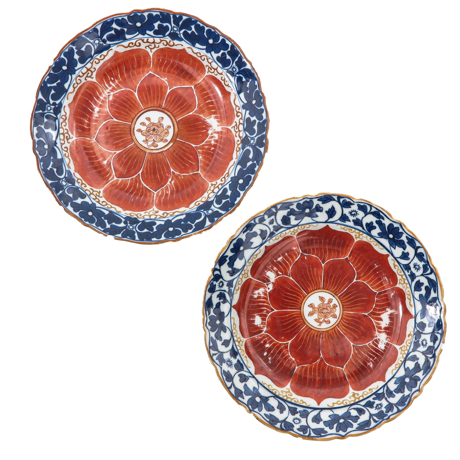 A pair of 2 Lotus Plates: Decorated with a large stylized lotus flower in iron-red and gilt, surrounded by underglaze-blue floral borders, 20 cm. in diameter, chip and hairline.