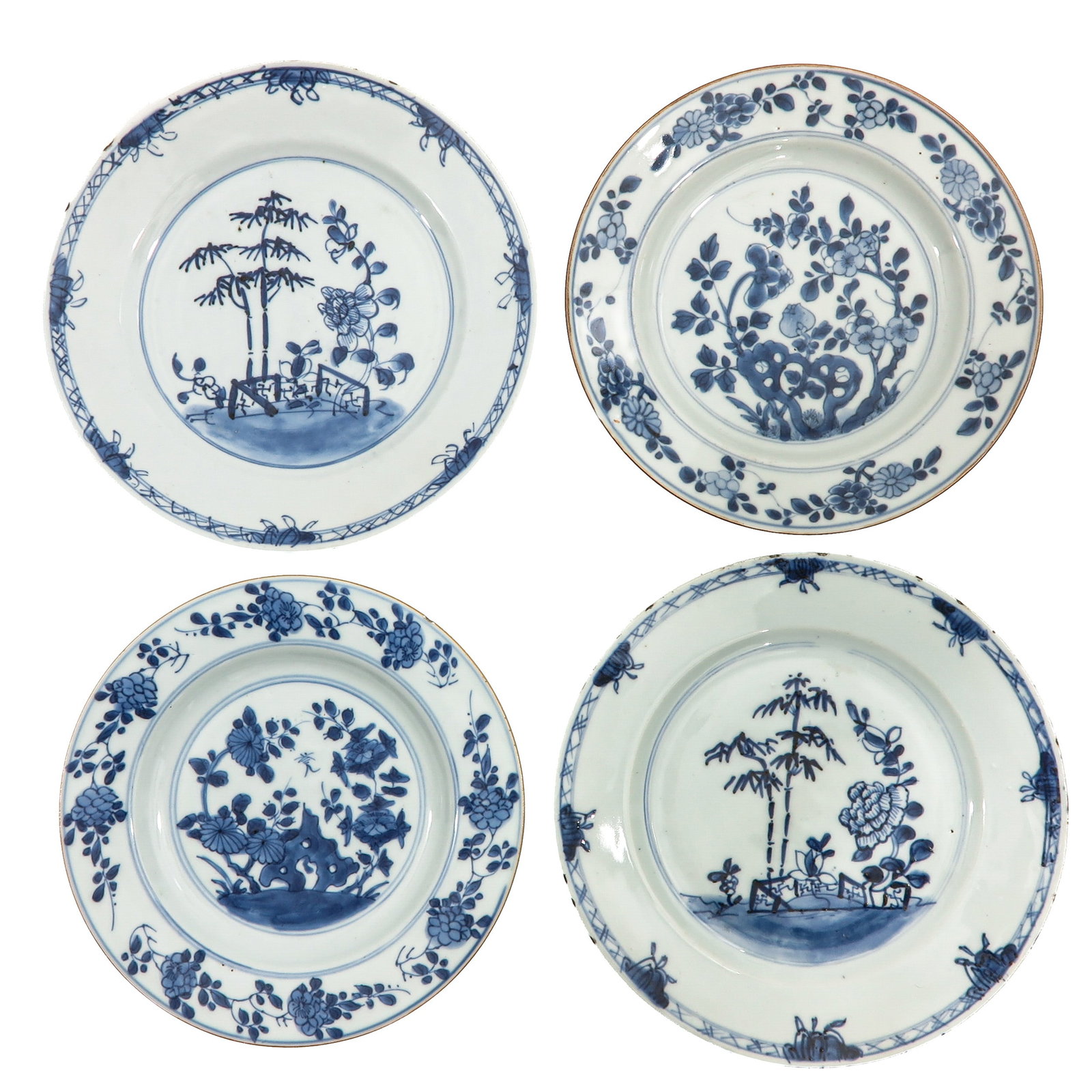A Group of 4 Blue and White Plates: In a variety of floral decors, 18th Century, 23 cm. in diameter, chip.