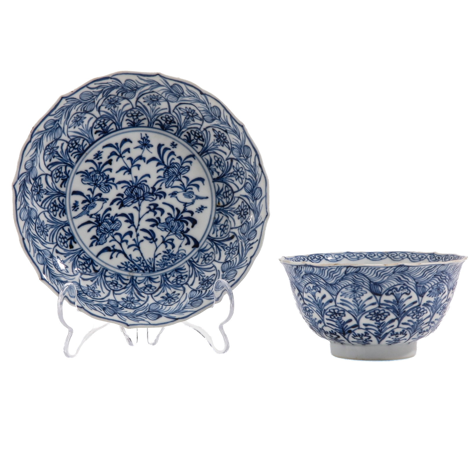 A Blue and White Cup and Saucer: Depicting flowering plants and birds within a richly decorated floral border, 18th Century, saucer is 16 cm. in diameter.