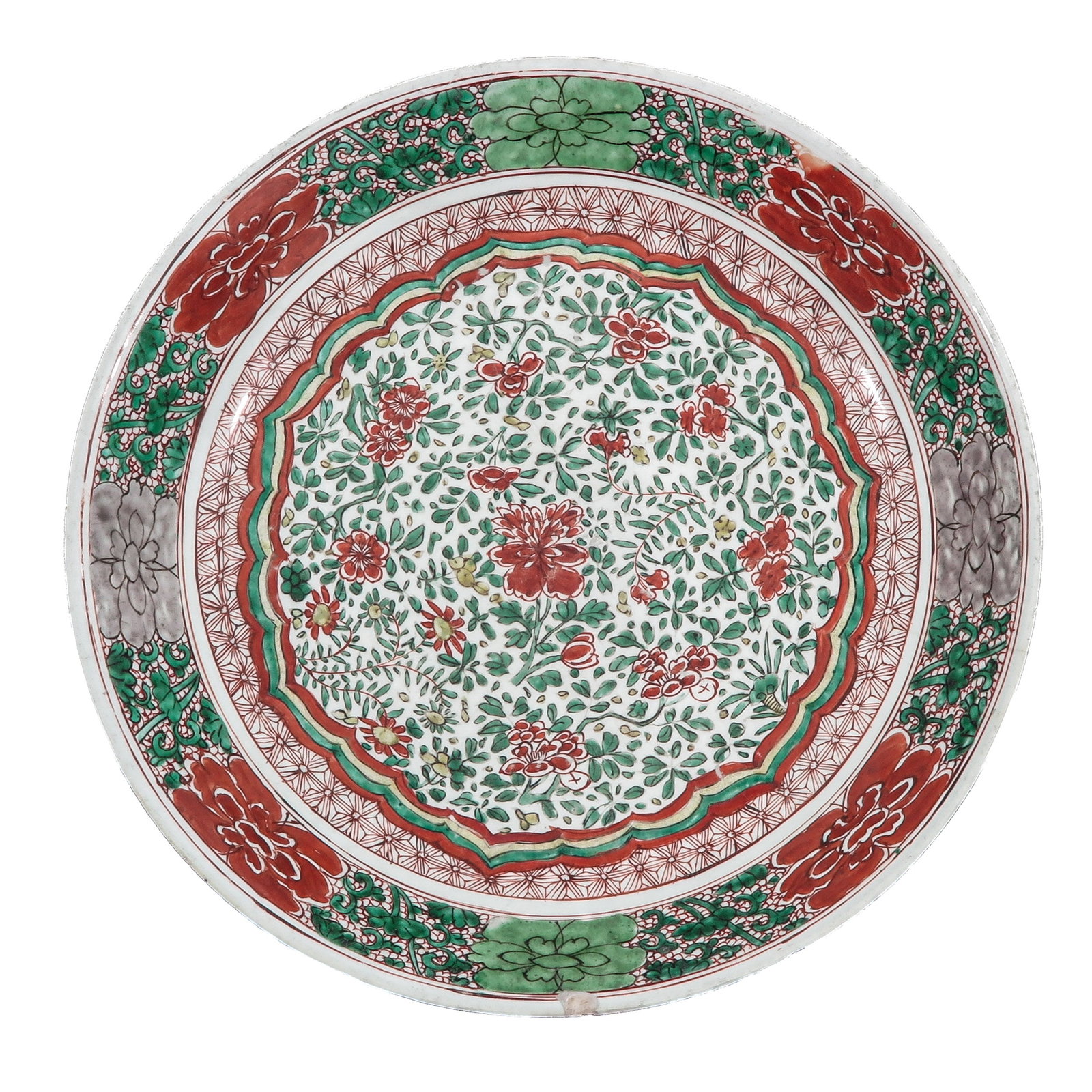 A Famille Verte Charger: Decorated with a dense floral design of peonies and scrolling foliage, Kangxi Period, 38 cm. in diameter, chip and hairline.