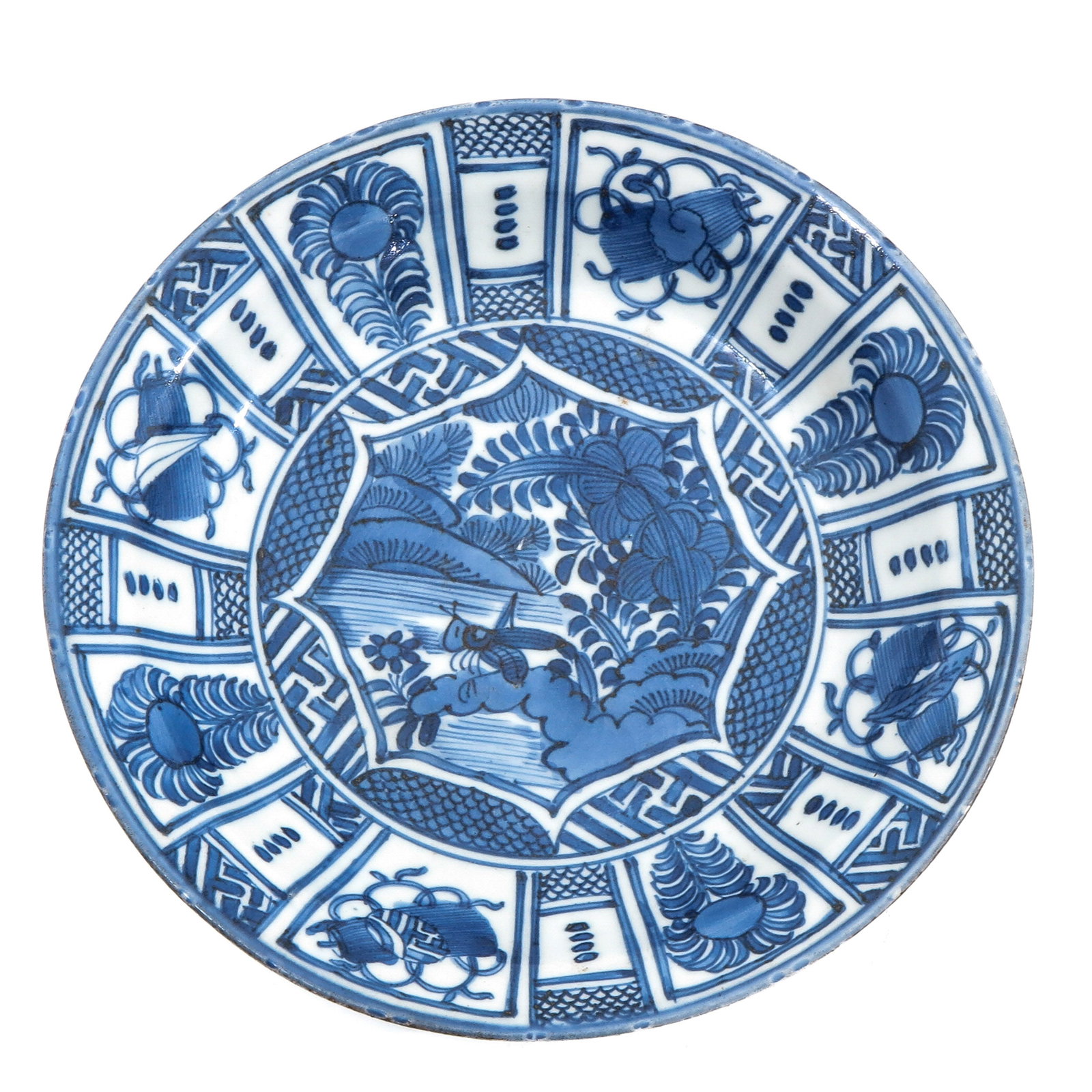 A Blue and White Plate: Depicting a scene with a cricket in a garden, 21 cm. in diameter.