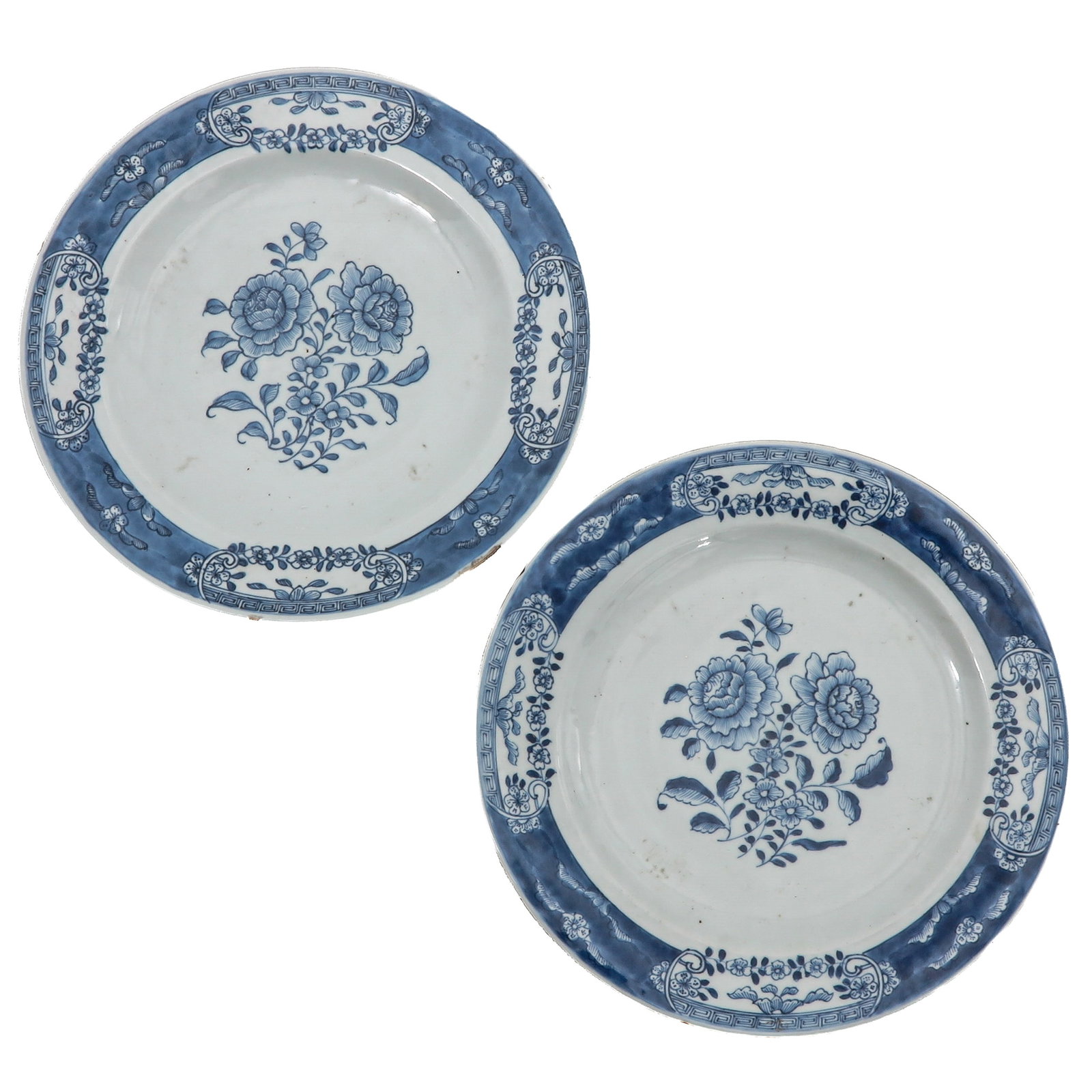 A Pair of Blue and White Plates: Decorated with a central floral spray within a diaper and floral border, circa 1800, 26 cm. in diameter, chip.