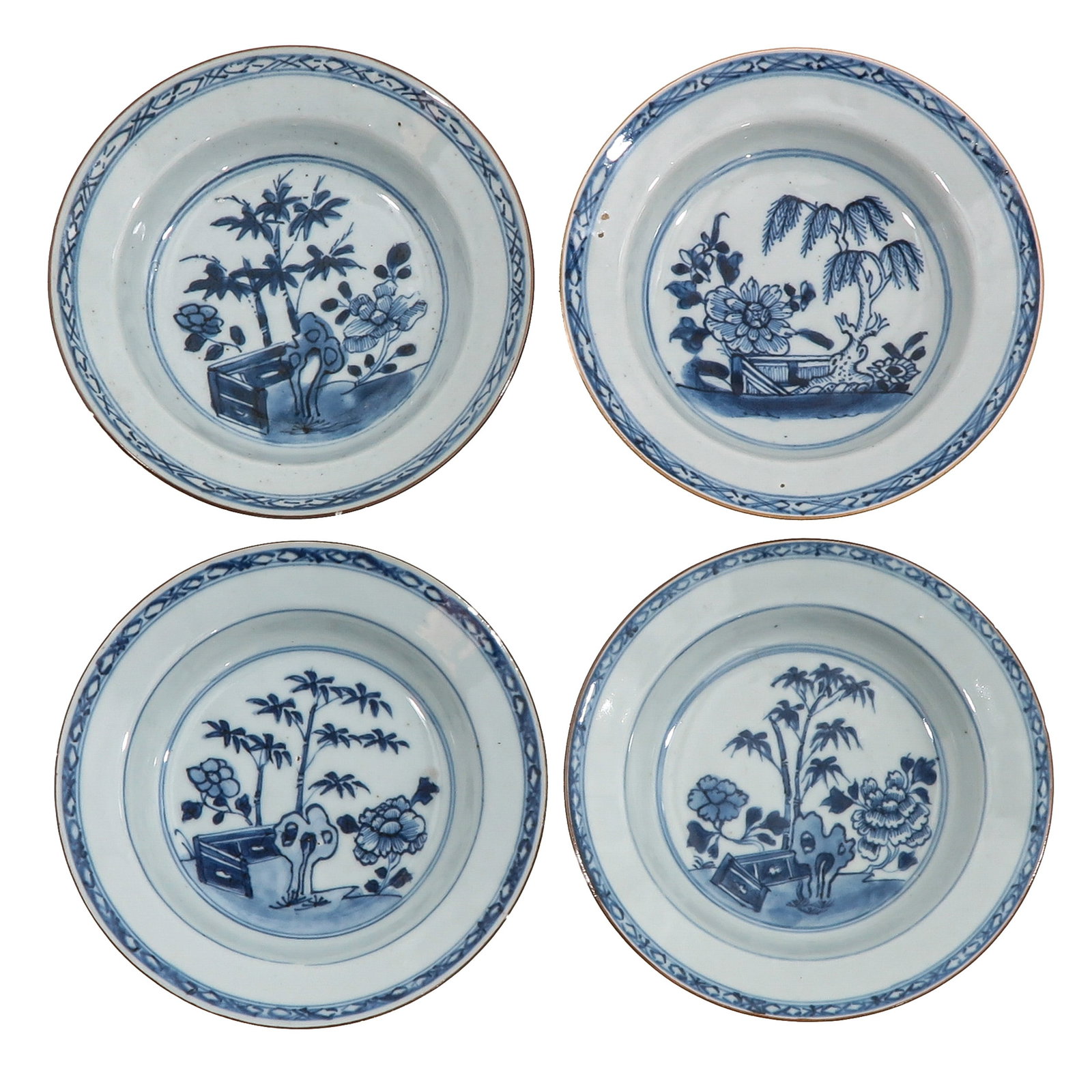 A Group of 4 Blue and White Plates: Each decorated with flowers, bamboo and scholar?s objects, ca. 1800, 16 cm. in diameter, chip and hairline.