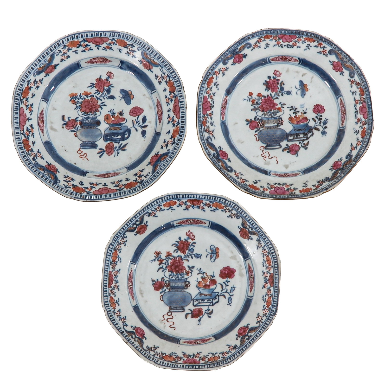 A Series of 3 Imari Octagonal Plates: Decorated with flowering urns, scholar?s objects and butterflies in underglaze blue and iron red enamels, 18th Century, 23 cm. in diameter, chip.