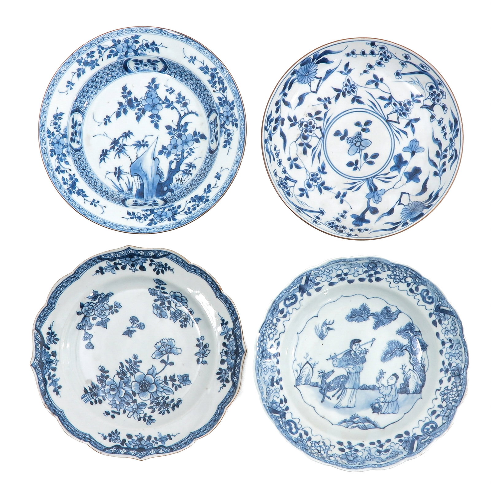 A Group of 4 Blue and White Plates: In a variety of decors, 18th Century, 23 cm. in diameter, chip and hairline.
