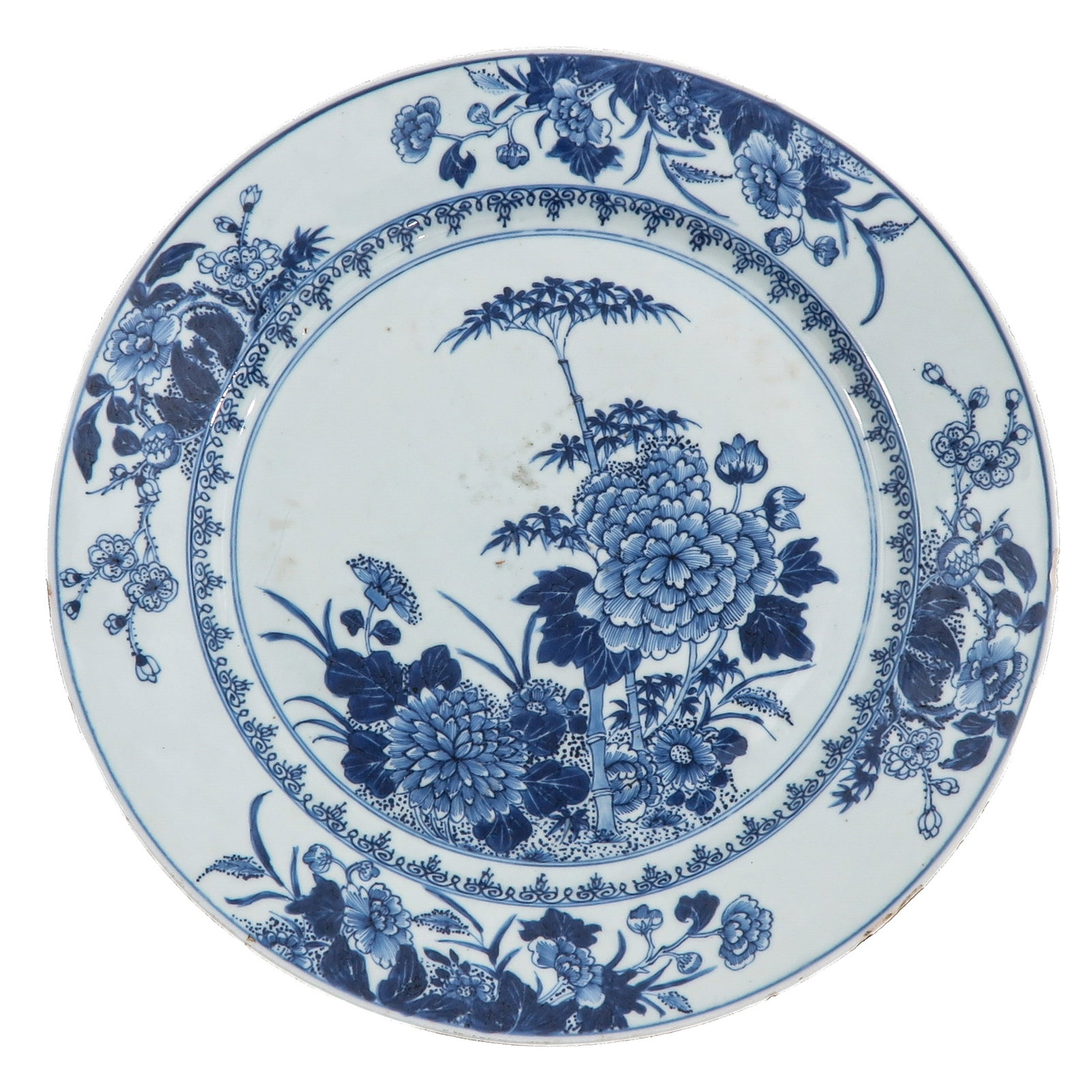 A Blue and White Charger: Decorated with flowering plants and bamboo within a floral border, 18th Century, 35 cm. in diameter, chip.