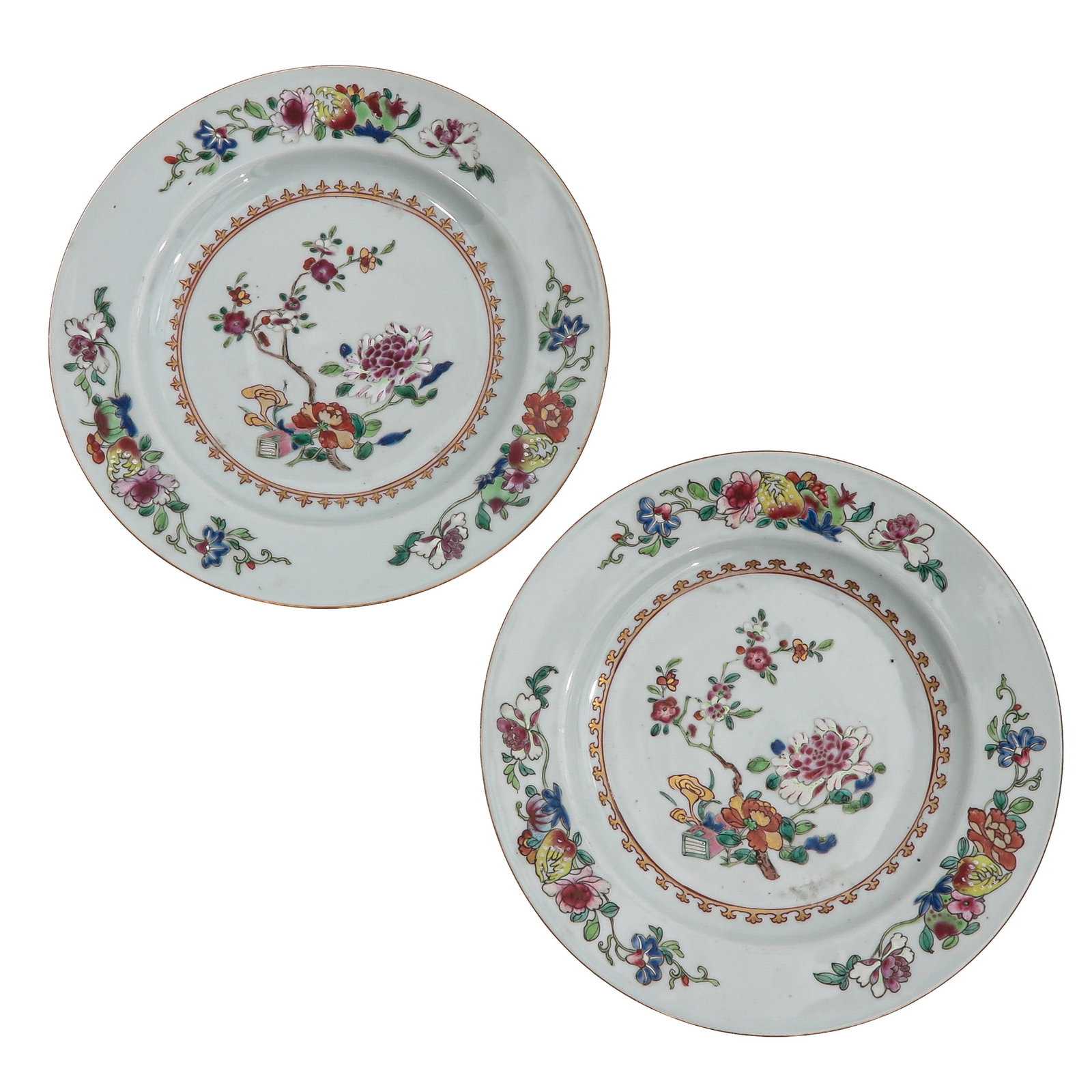 A Pair of Famille Rose Plates: decorated with flowering branches and floral sprays within a floral border, 18th Century, 26 cm. in diameter, chip.