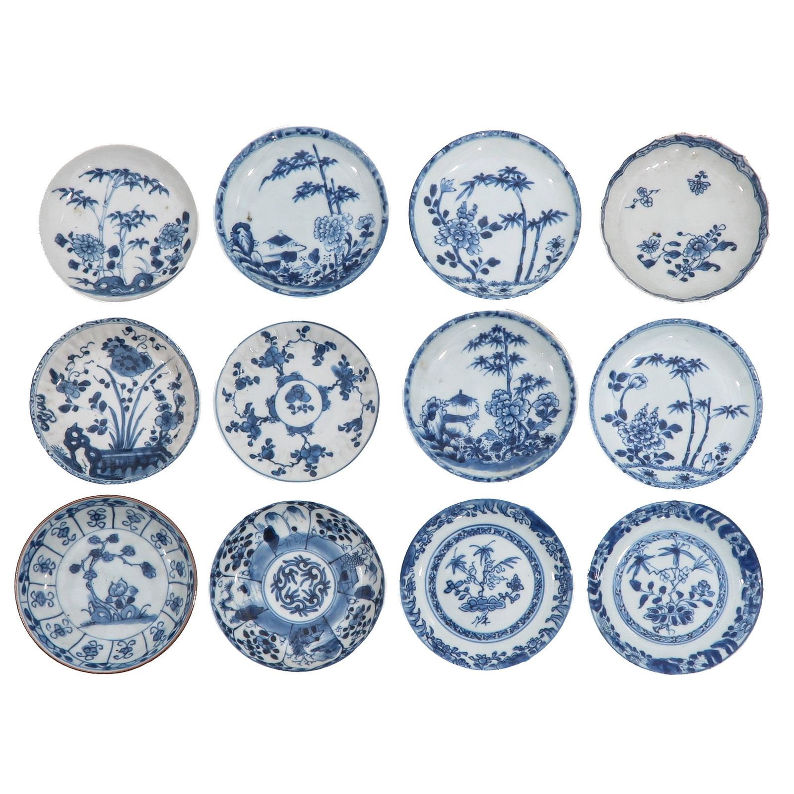 A Group of Blue and White Saucers: Variously decorated with bamboo, flowering plants, rockwork and landscape scenes, largest is 12 cm. in diameter, chip and hairline.