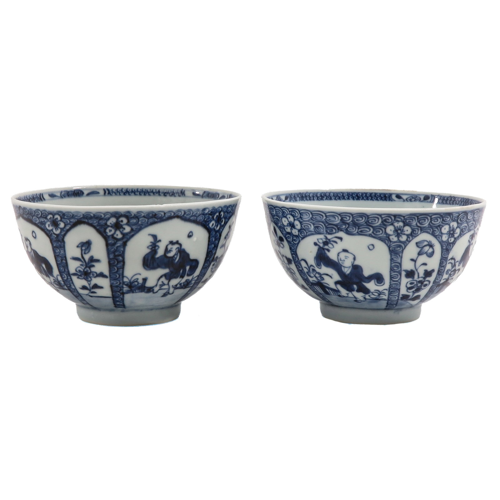 A Pair of Blue and White Bowls: Decorated with figures alternating with flowering plants, reserved against a patterned ground, 11 cm. in diameter.