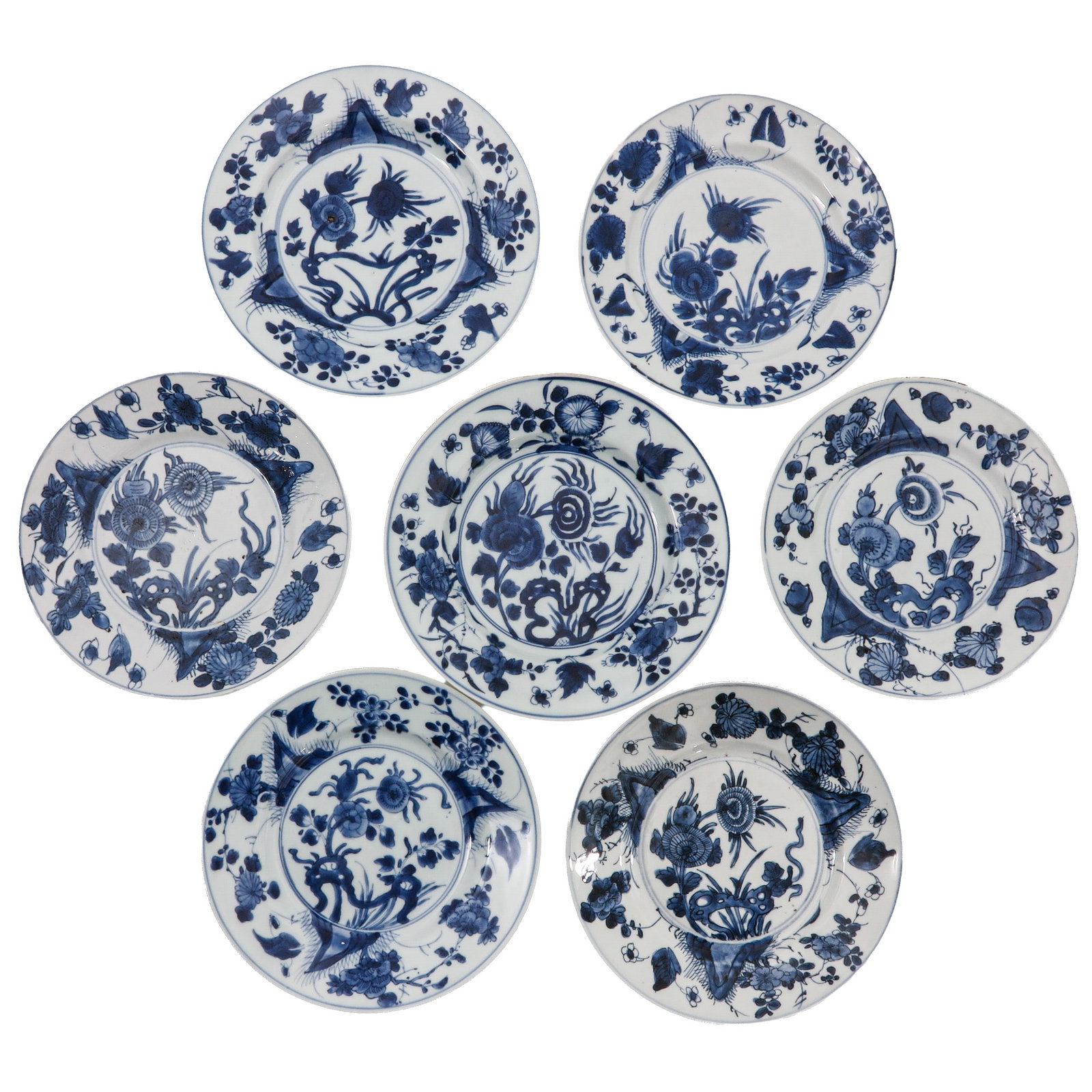 A Group of 7 Blue and White Plates: Decorated with flowering plants and stylized rockwork, 18th Century, 22 cm. in diameter, chip and hairline.