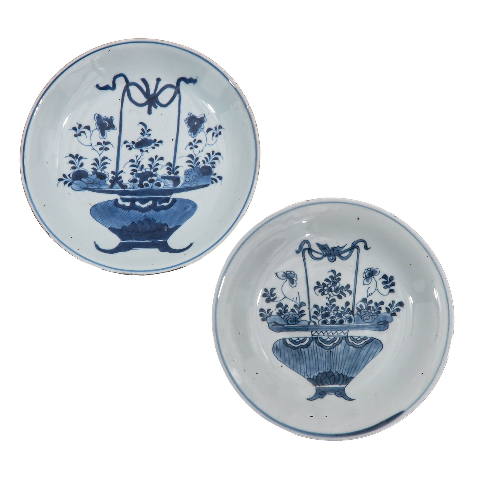 A Lot of 2 Blue and White Plates: Decorated with flowers baskets, 18th Century, 21 cm. in diameter, chip.