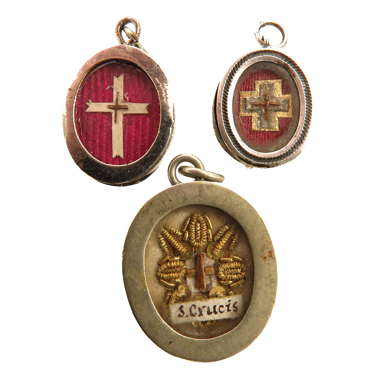 A Group of 3 Thecae: consisting of 3 thecae, each with a relic of the Holy Cross, executed in different mounts, you are purchasing the thecae, the relics are a gift, largest measurement 2 x 3 cm.