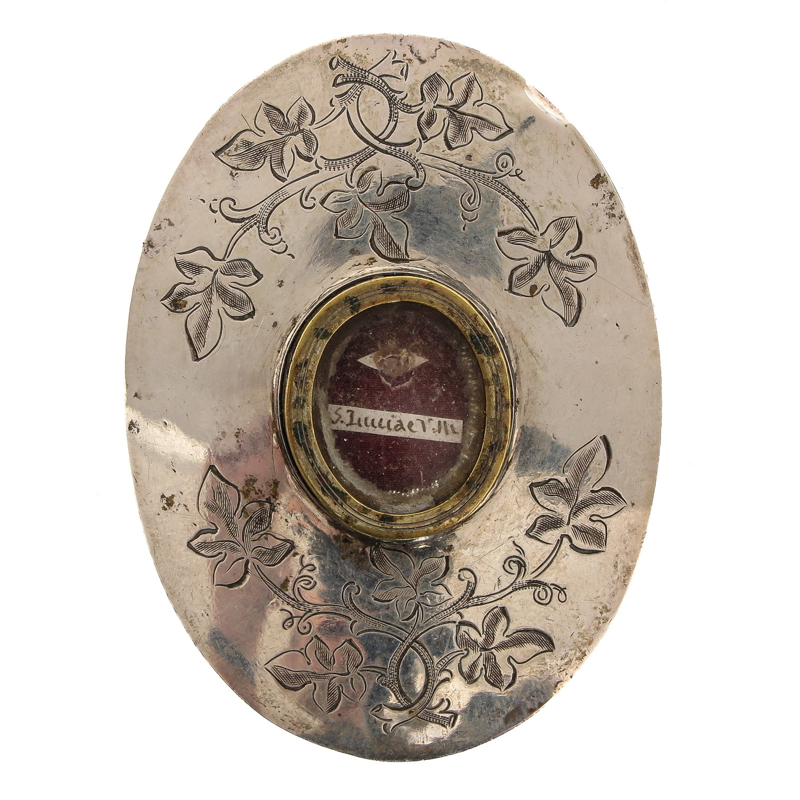 A Sealed Theca: containing relic of Saint Julia, virgin and martyr, patron saint of Corsica, placed behind glass in an engraved oval mount with leaf ornaments, you are purchasing the theca, the relic is a gift, 5 x