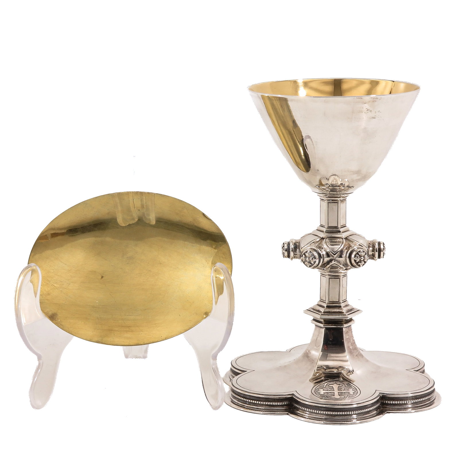A Chalice: with paten, hallmarked V on the foot, Neo-Gothic, with quatrefoil foot, provided with a cross, cross-shaped node with floral decoration and partly gilt cuppa, height 21 cm.