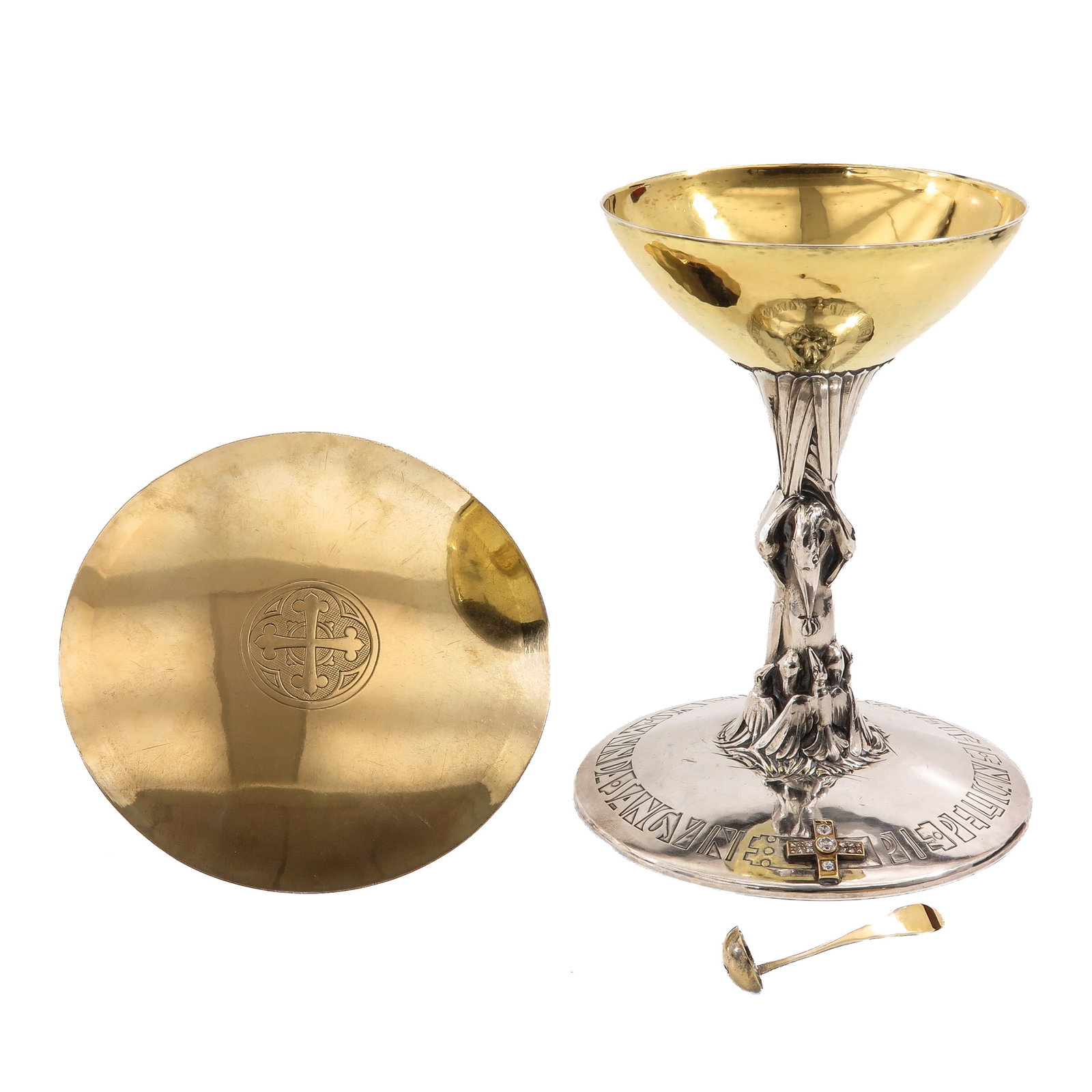 A Chalice: with paten and spoon, hallmarked 900/1000, partly gilt, with sculptural node in the form of a pelican feeding her young, a diamond-set cross on the foot and an engraved cross on the paten, height 20