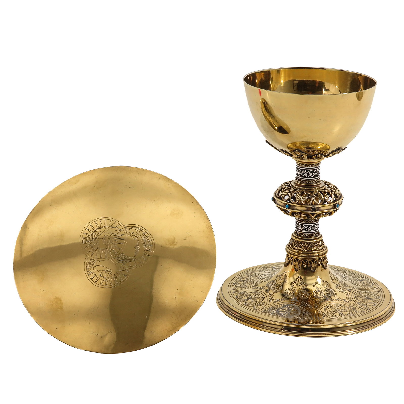 A Chalice: with paten, Neo-Gothic, richly gilt, with engraved foot, openwork node with blue cabochons, and a paten decorated with an engraved depiction of a dove, a fish and a hand, height 19 cm.