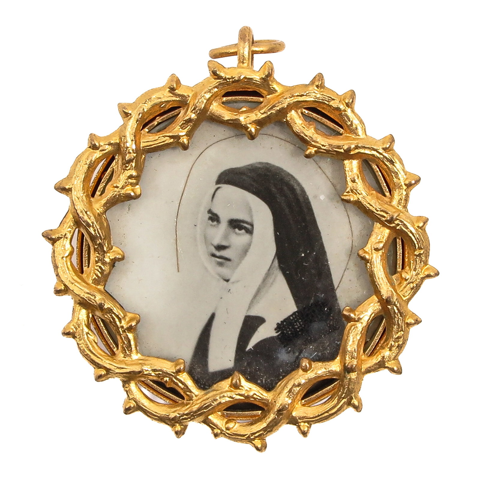 A Relic Pendant: of gilt metal with portrait, probably depicting Saint Therese of Lisieux, diameter 3 cm.