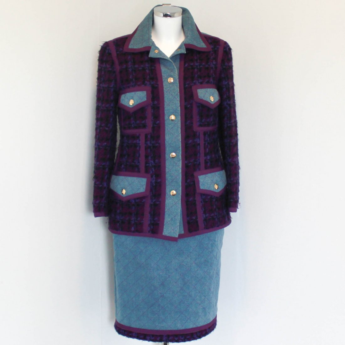 Chanel Denim & Tweed Suit: Purple and blue wool blend denim trim wool blazer and skirt from Chanel. Featuring a classic collar with purple stitching and trim, front snap button closure with gold "CC" detail, and four front flap