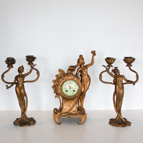3 Piece Art Nouveau Clock Set: An Art Nouveau Gilded Spelter Three Piece Clock Set. Circa 1900 Gilded set featuring three diaphanously clad nymphs ,the central figure leans against a garland decorated clock face, the remaining two 