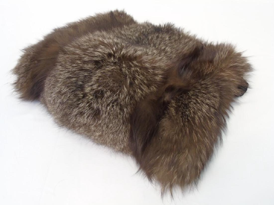 Square Raccoon Muff with Textured Back Pocket: Square Raccoon Muff with back zippered pocket for storage, in textured black fabric. Measures 16 x 3.5 inches.