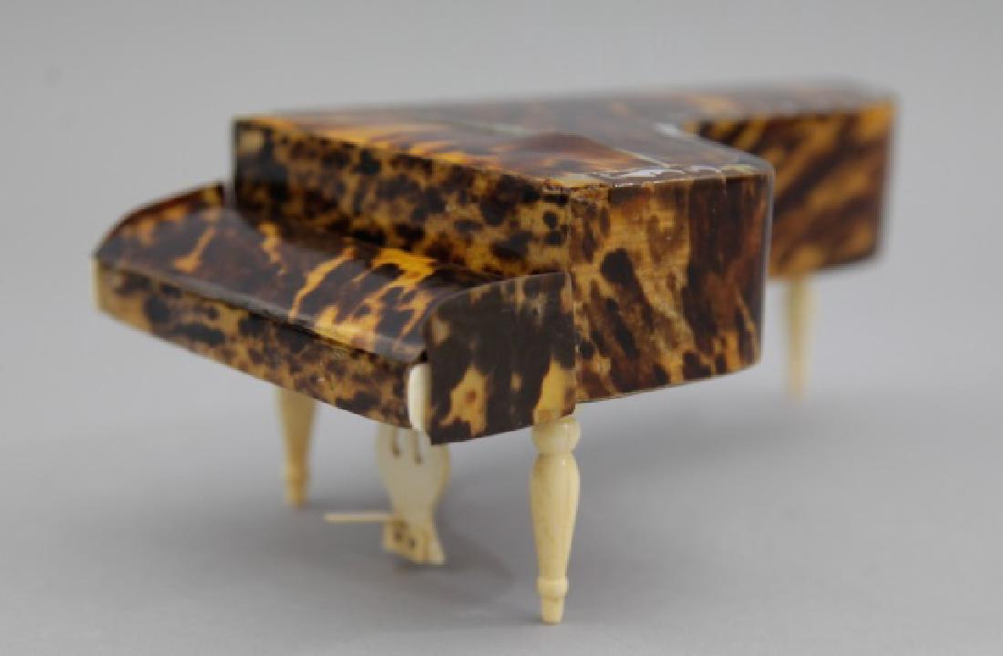Antique Tortoise Shell Miniature Baby Grand Piano: Antique Tortoise Shell Miniature Baby Grand Piano, with Mother of Pearl inlay and bone detailing. Having an articulated key board cover and hand-painted bone key board. Measures 3 x 9 x 4.5 inches.