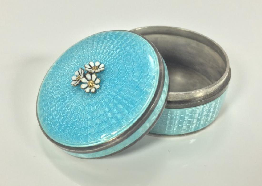 Fine Guilloche Enamel Sterling & Gold Table Box: Fine Guilloche Enamel Sterling & Gold Table Box. Featuring three white enamel and yellow gold flowers at the top. Hallmarked and stamped STERLING. Measures 1.5 inches in diameter.