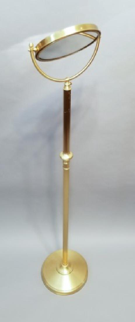 Brushed Gold-Tone Standing Makeup / Counter Mirror: Brushed Gold-Tone Standing Makeup Mirror; having a pivoting mirror with a magnification side. Measures 56 inches tall.