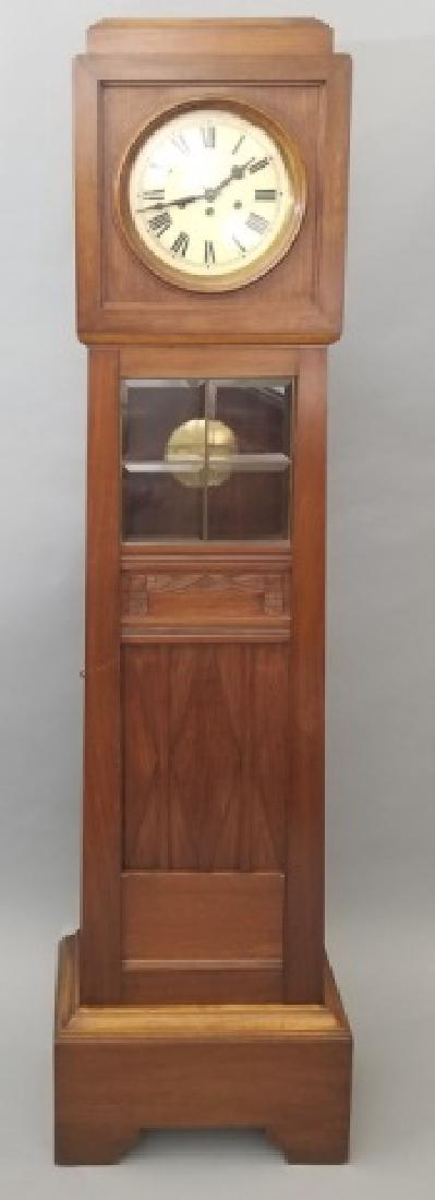 Mahogany Case Pendulum Clock with Beveled Glass: Mahogany Case Pendulum Clock with Beveled Glass; having roman numerals, carved wood accents, and 2 key-latch doors. Measures 70 x 15 x 7 inches.