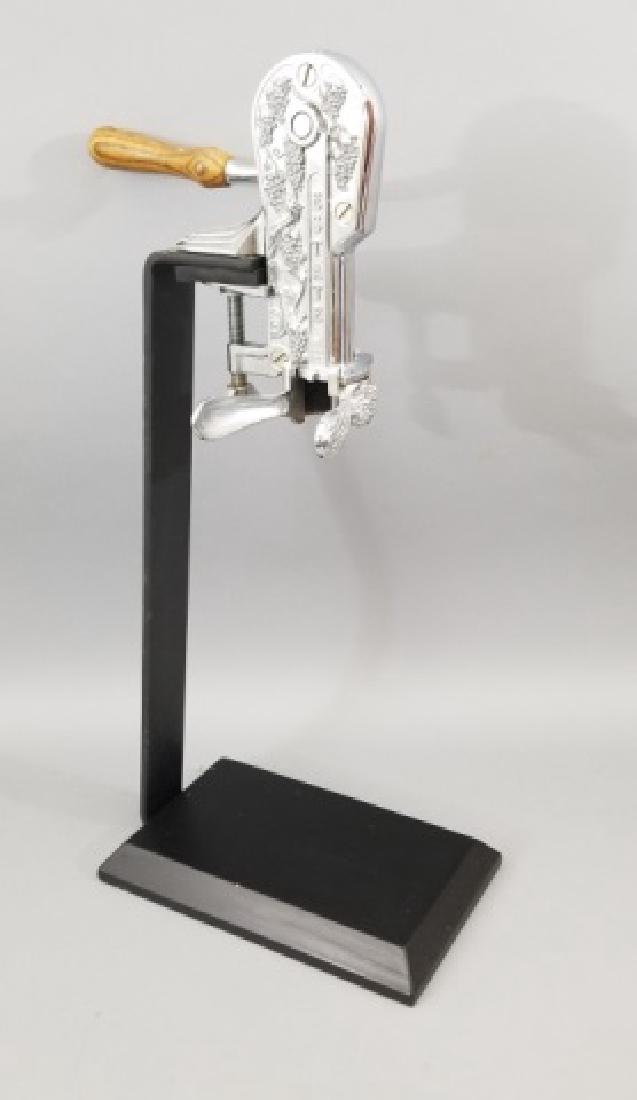 "Estate" Grape Cluster Motif Counter Bottle Opener: "Estate" Grape Cluster Motif Counter Bottle Opener. Marked Estate at top. Black stand and base. Measures 23.5 inches in height. Wine cellar, kitchen, bar, restaurant accessory.