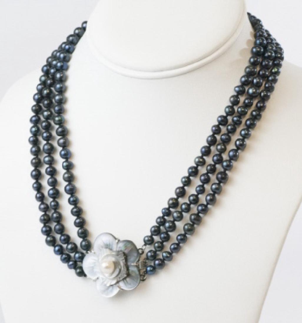 Triple Strand Black Pearl Necklace w Floral Clasp: Triple Strand Black Pearl Necklace w Floral Clasp. Tahitian style black pearl hand knotted necklace with large carved flower clasp. Measures 17 inches in length.